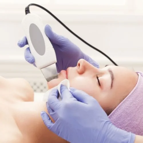 A handheld skin-resurfacing device being used on a patient’s face